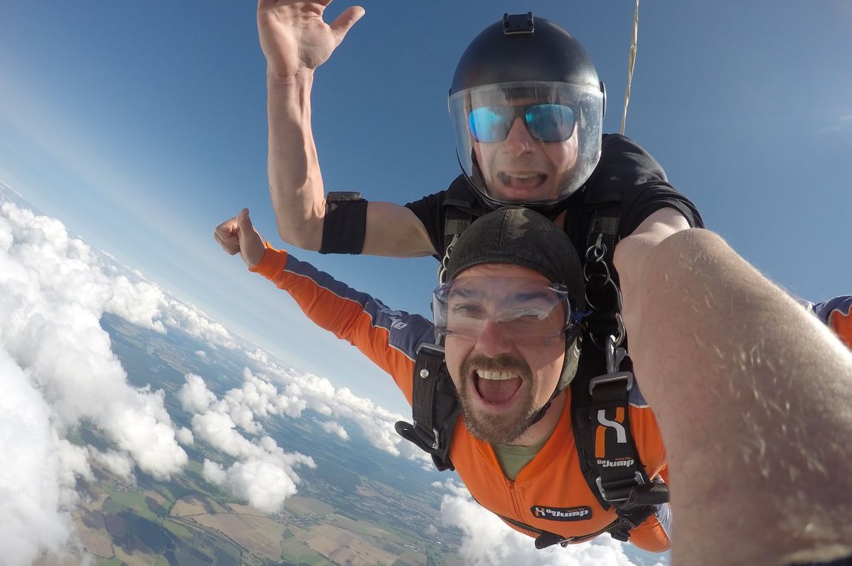 Das Bild zeigt einen Tandemsprung aus dem Flugzeug heraus.