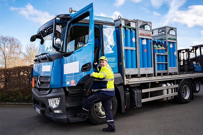 Das Foto zeigt einen Berufskraftfahrer-Azubi beim Einsteigen in einen LKW, beldaden mit technischen Gase