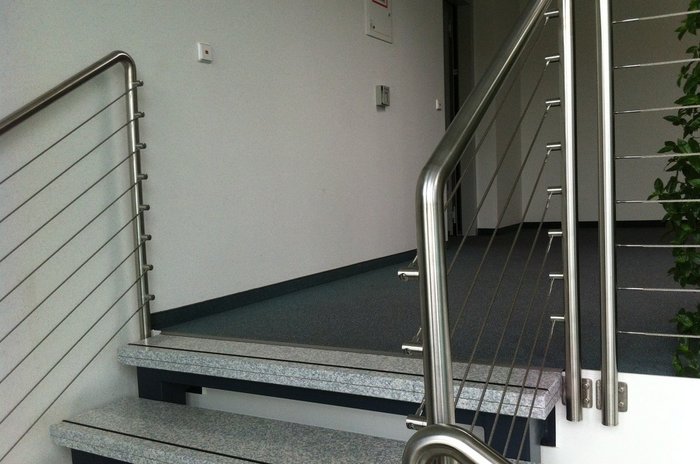 Das Foto zeigt eine Metalltreppe mit Geländer