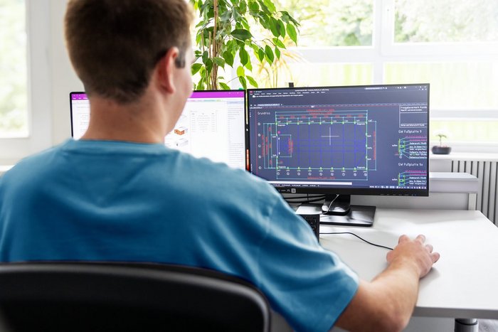 Das Foto zeigt einen Studenten an einem PC-Arbeitsplatz