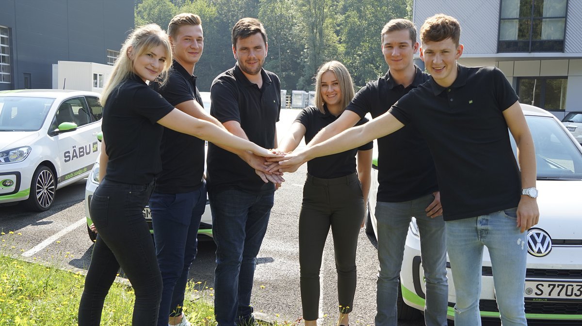 Das Foto zeigt 6 junge Menschen die sich die Hände reichen