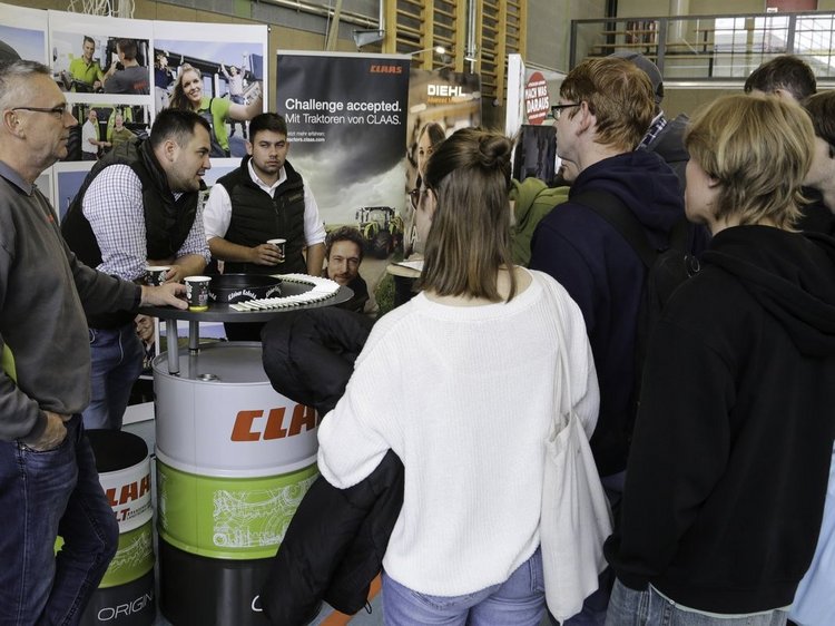 Impressionen der Lehrstellenbörse Zehdenick 2025 Das Foto den Messestand von BLT Löwenberg - drei Standbetreuer im Gespräch mit einer Gruppe Jugendlichernen Messestand mit 3 Psersonen im Gespräch